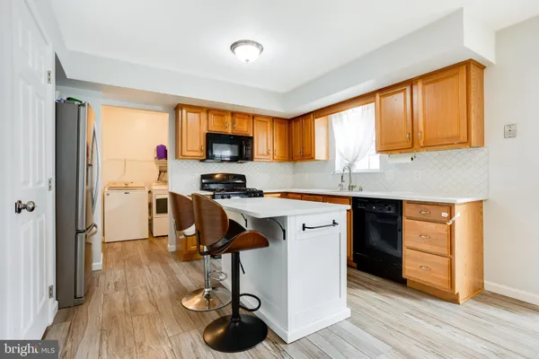 a kitchen with a sink appliances cabinets and a window