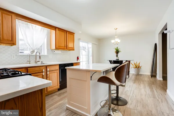 a kitchen with stainless steel appliances granite countertop a sink a stove a refrigerator cabinets and living room view