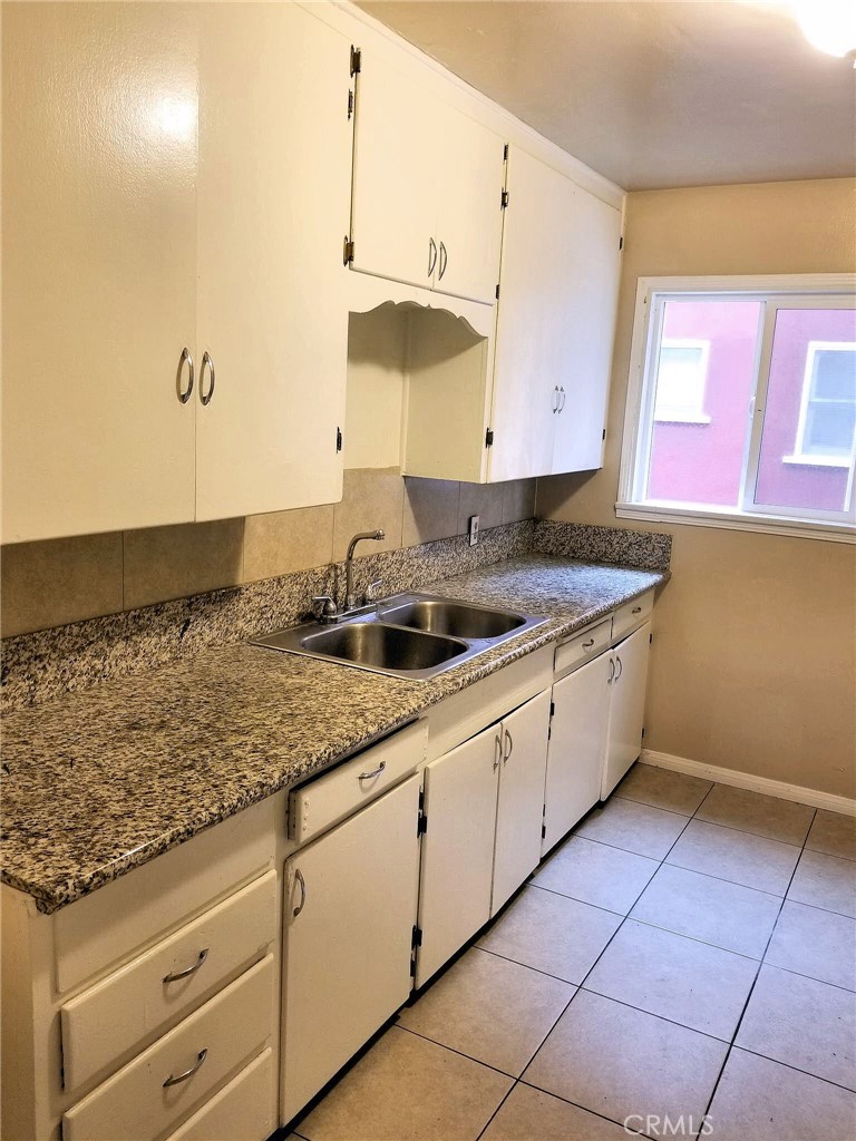 1405 South Broadway Santa Ana, CA 92707 - Photo 4 of 11 a kitchen with granite countertop a sink a stove and cabinets