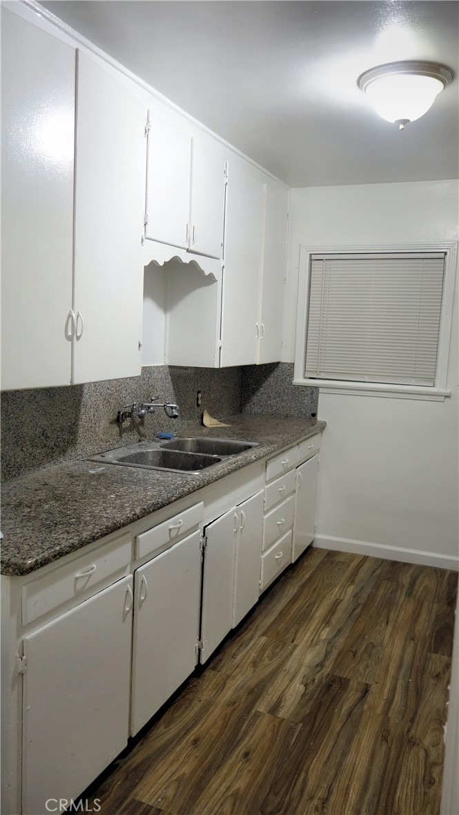 1405 South Broadway Santa Ana, CA 92707 - Photo 6 of 11 a kitchen with granite countertop white cabinets and sink