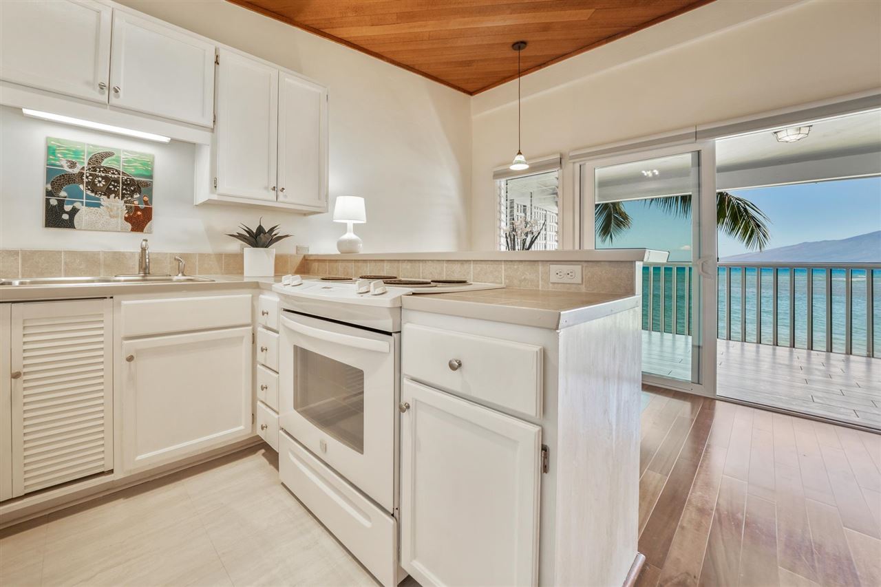 Lower Honoapiilani Road, Unit 210 Lahaina, HI 96761 - Photo 3 of 29 a kitchen with white cabinets and white appliances