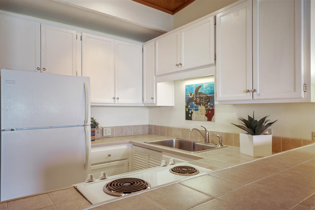 Lower Honoapiilani Road, Unit 210 Lahaina, HI 96761 - Photo 4 of 29 a kitchen with a sink a refrigerator and cabinets