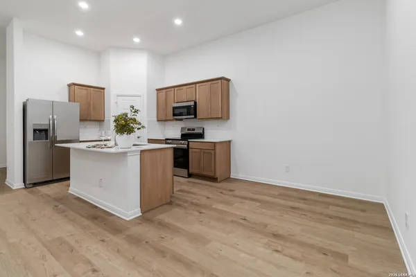a kitchen with stainless steel appliances a refrigerator and a stove top oven