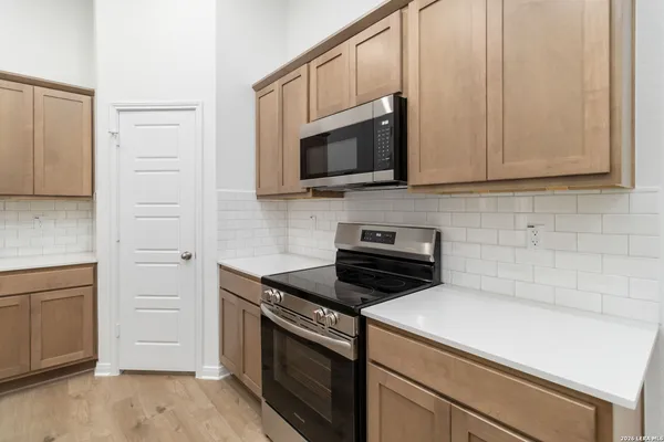 a kitchen with microwave cabinets and stove top oven