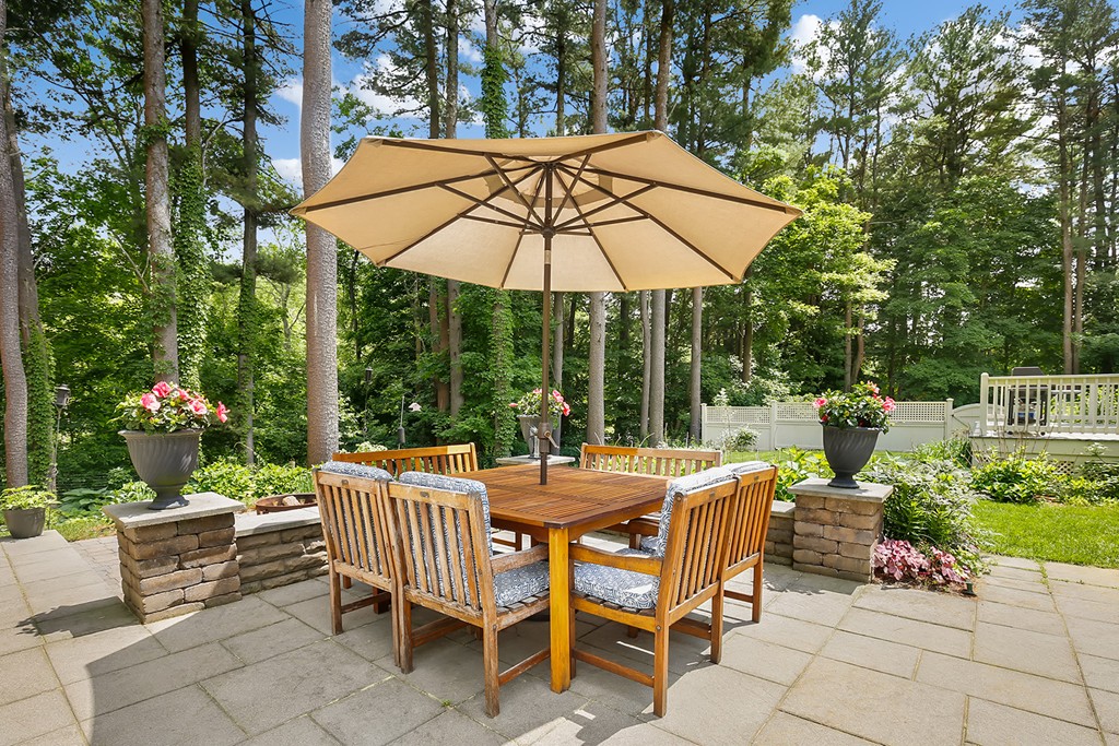 117 Perkins Row Topsfield, MA 01983 - Photo 25 of 28 a view of a patio with a dining table and chairs under an umbrella