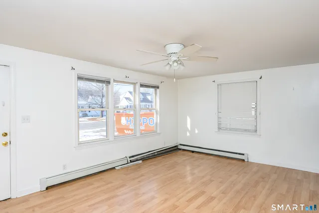 an empty room with wooden floor and windows