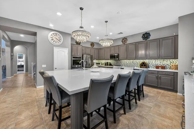a view of kitchen with stainless steel appliances granite countertop cabinets and entryway