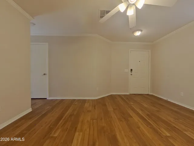 a view of an empty room with wooden floor
