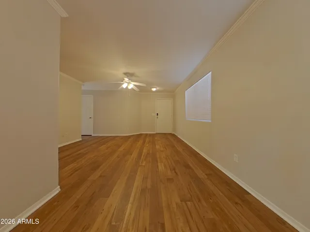 a view of an empty room with wooden floor
