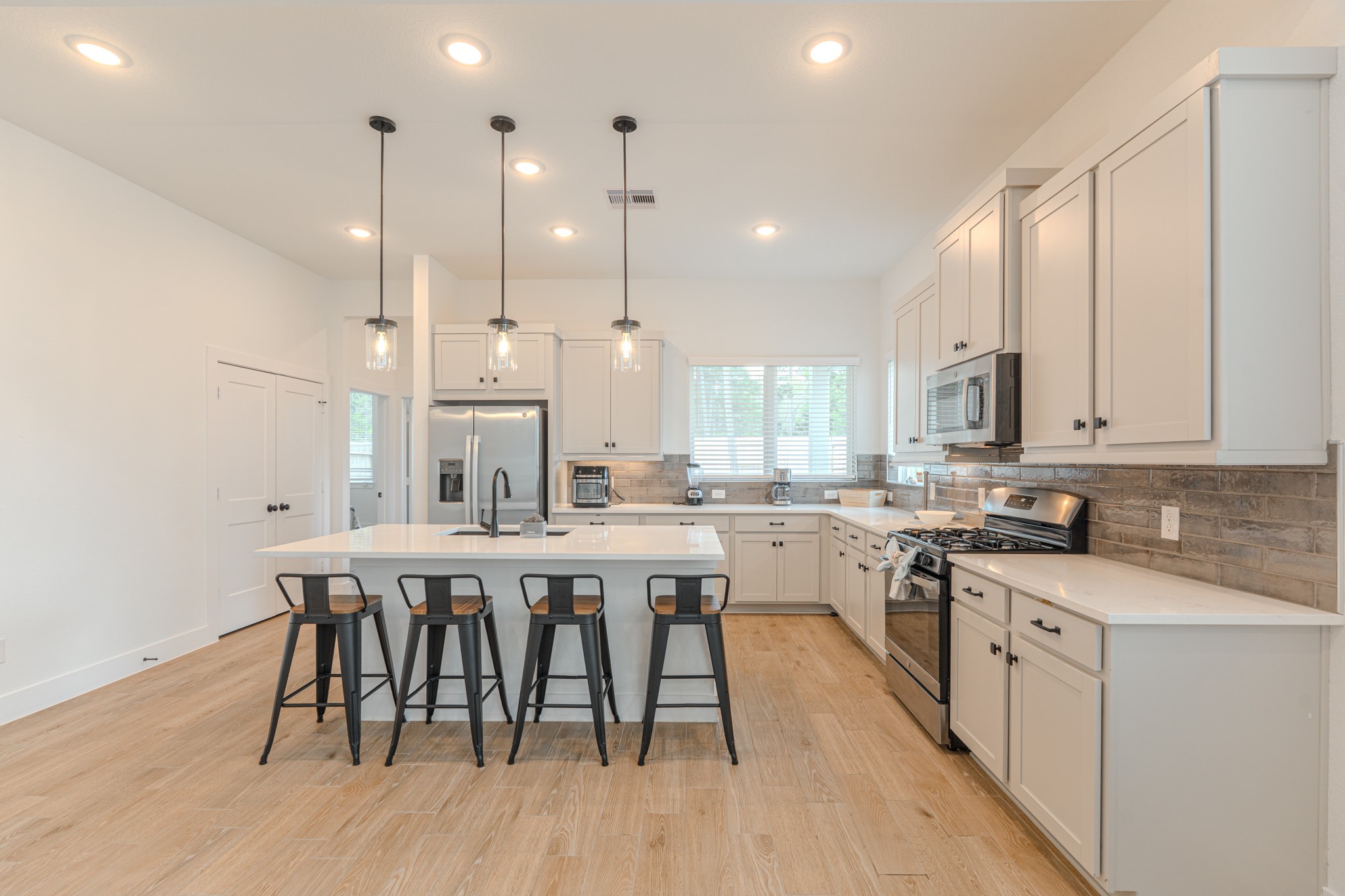 214 Prairie Rose Court Conroe, TX 77318 - Photo 12 of 30 a kitchen with a dining table chairs wooden cabinets and white appliances