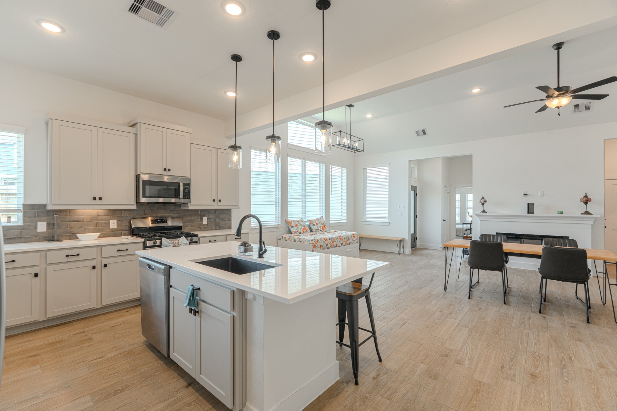214 Prairie Rose Court Conroe, TX 77318 - Photo 15 of 30 a kitchen with kitchen island a dining table chairs sink and wooden floor