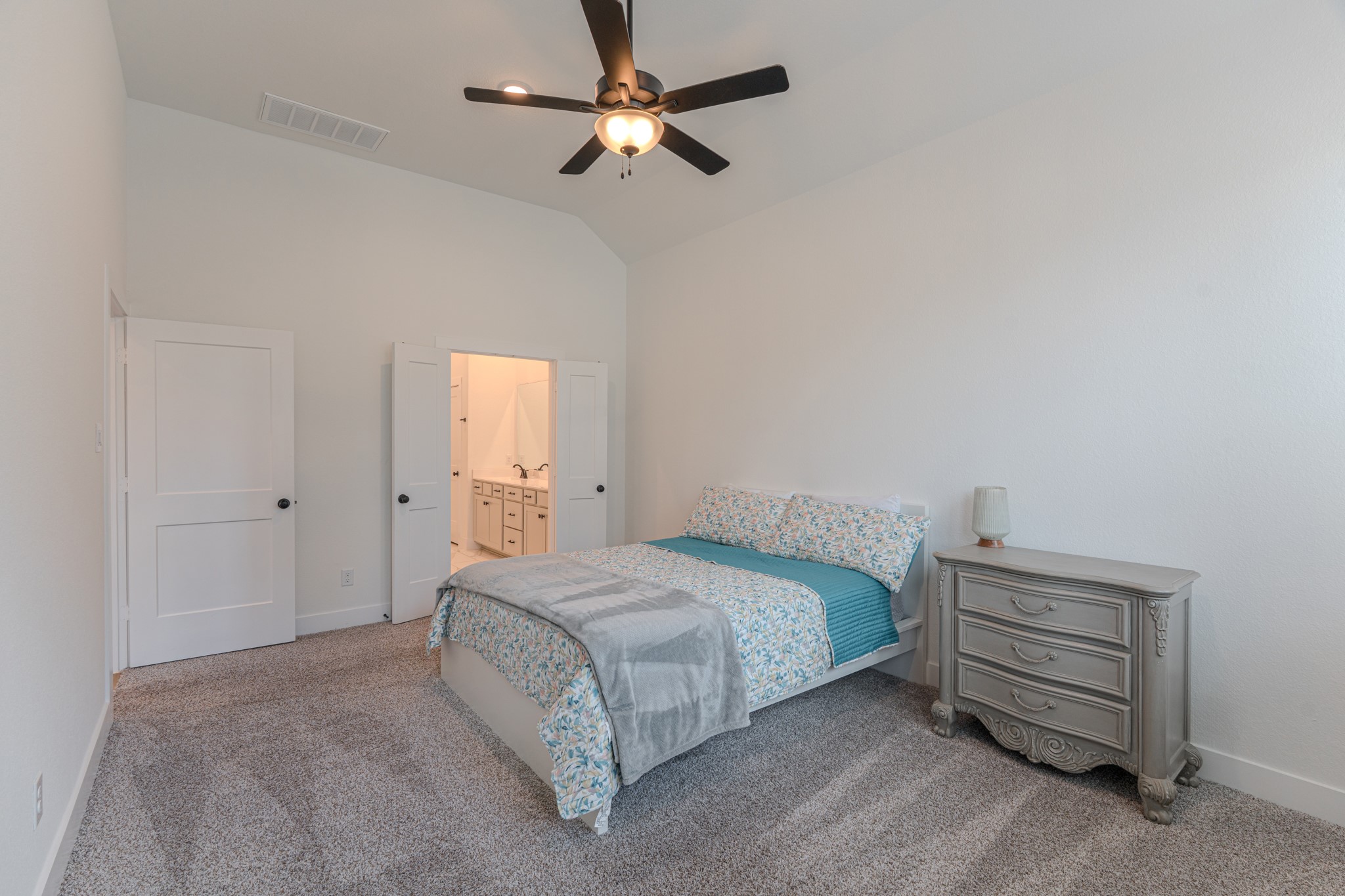 214 Prairie Rose Court Conroe, TX 77318 - Photo 17 of 30 a bedroom with a bed and a chandelier