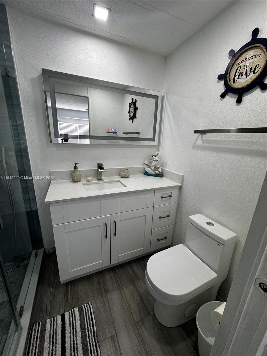 228 Orchid Street Tavernier, FL 33070 - Photo 20 of 43 a bathroom with a toilet a sink and mirror