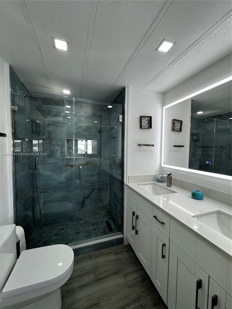 228 Orchid Street Tavernier, FL 33070 - Photo 26 of 43 a bathroom with a granite countertop sink a toilet a mirror and shower