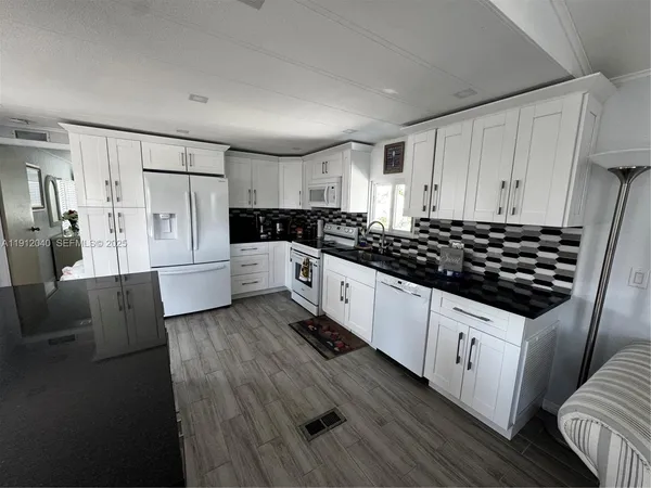 a kitchen with granite countertop a sink stove and refrigerator