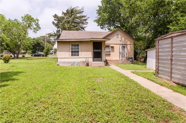 a front view of a house with a yard and trees