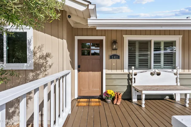 a view of house with wooden deck and furniture