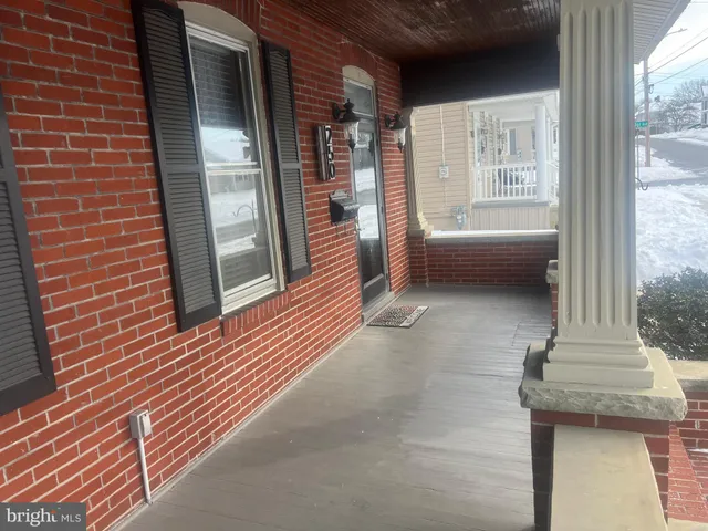 a view of a hallway with wooden floor and bathroom