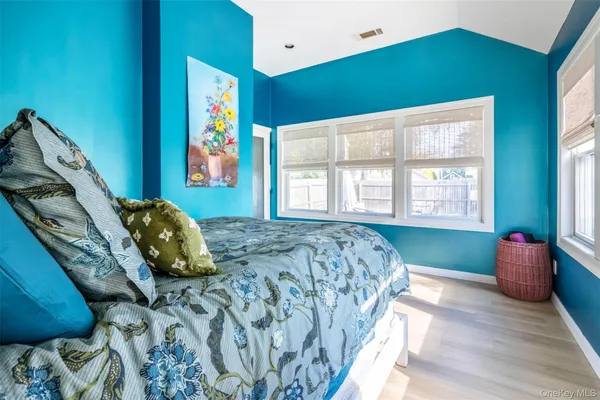 a bedroom with a bed and painting on the wall