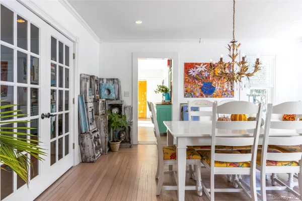 a dining room with furniture a livingroom view and wooden floor