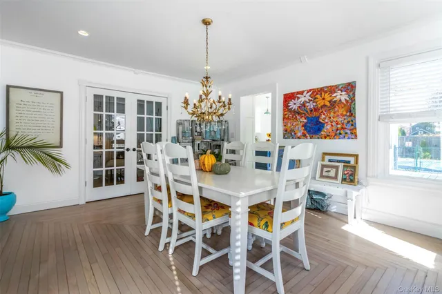 a dining room with furniture a chandelier and wooden floor