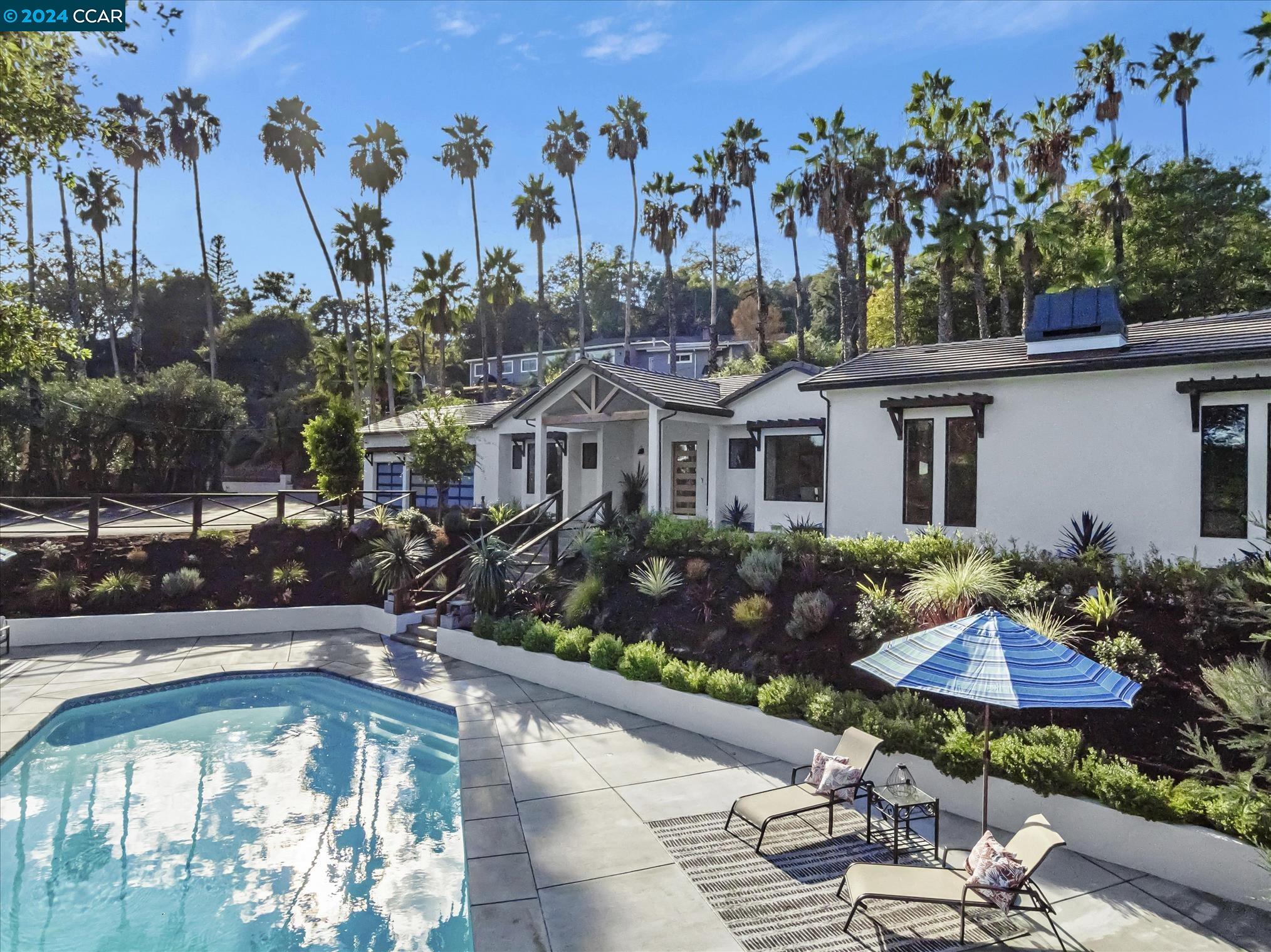 a view of a house with swimming pool and sitting area