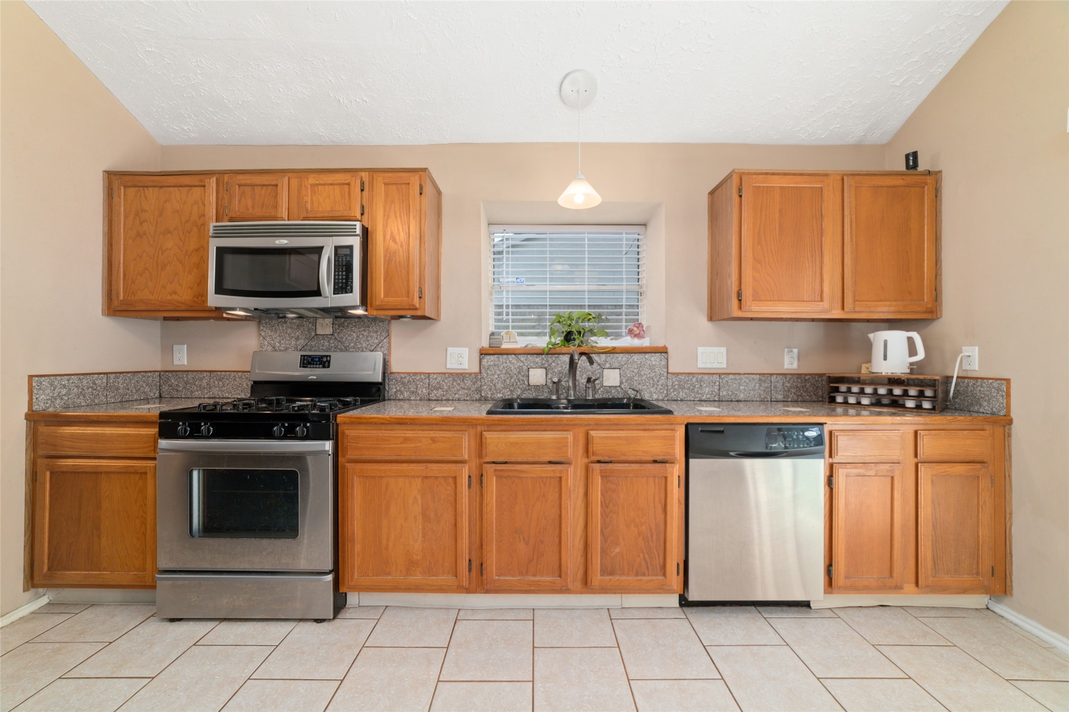 3315 Haydee Road Spring, TX 77388 - Photo 14 of 29 a kitchen with stainless steel appliances granite countertop a stove top oven a sink and a microwave