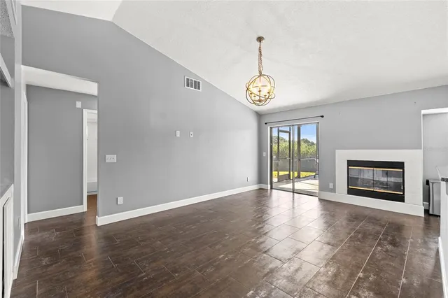 a view of an empty room with window and fireplace