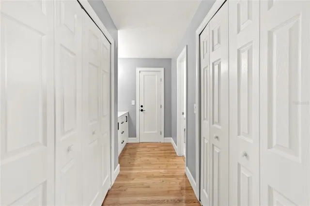 a view of a hallway with wooden floor and closet
