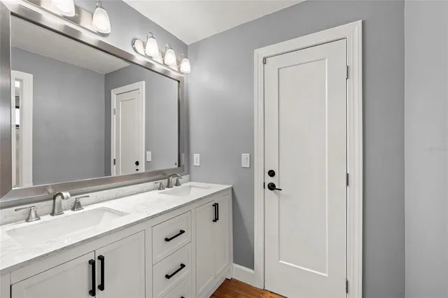 a bathroom with a double vanity sink and a mirror