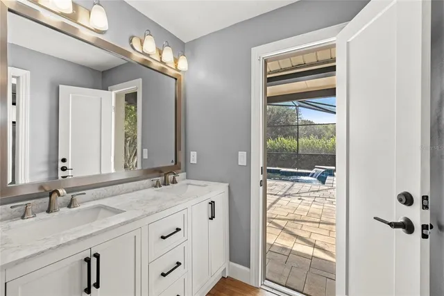 a bathroom with a granite countertop sink and a mirror