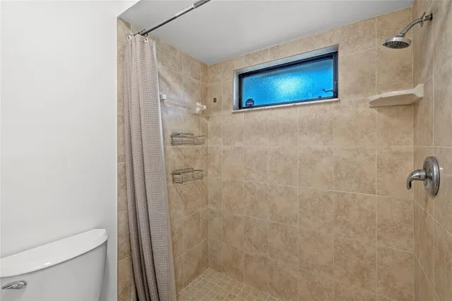a bathroom with a toilet and a shower
