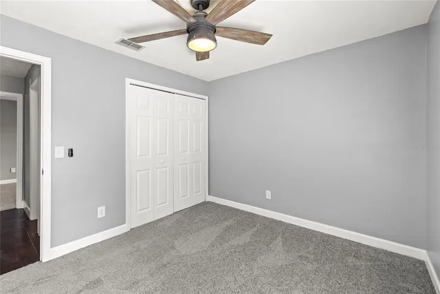 an empty room with a chandelier fan