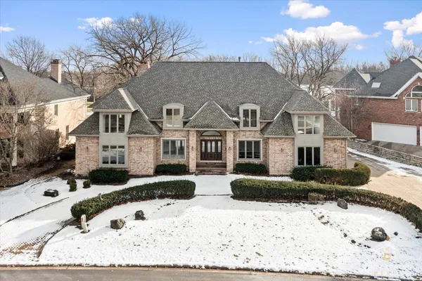 a front view of a house with a yard covered in snow