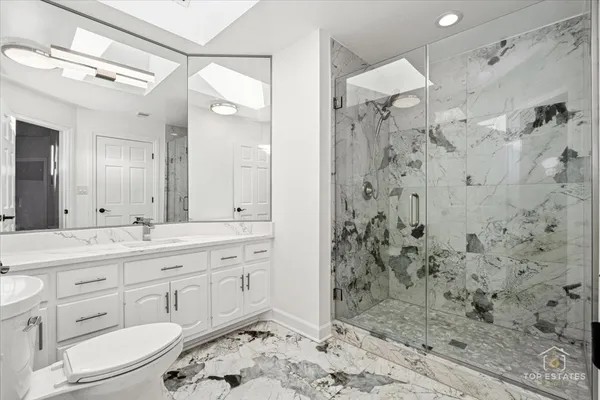 a bathroom with a double vanity sink mirror and shower