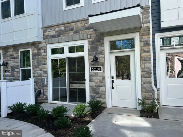 a view of a brick house with a large windows and plants