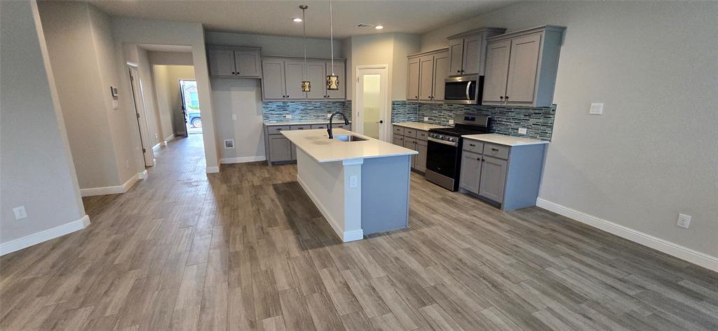 2432 O'Connor Rnch Drive Weatherford, TX 76087 - Photo 12 of 20 a large kitchen with a wooden floor and a stove top oven