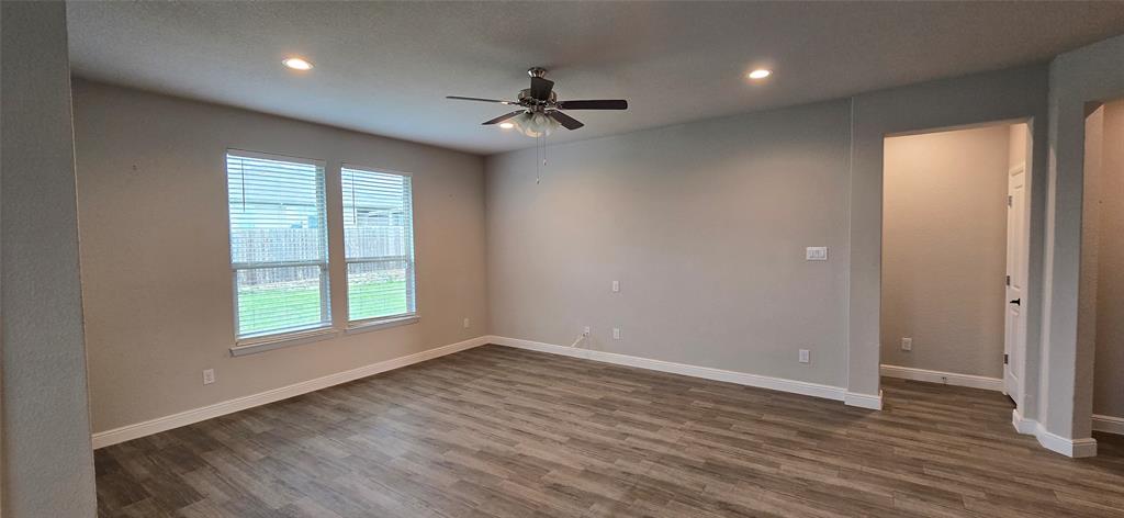 2432 O'Connor Rnch Drive Weatherford, TX 76087 - Photo 13 of 20 an empty room with wooden floor chandelier fan and windows