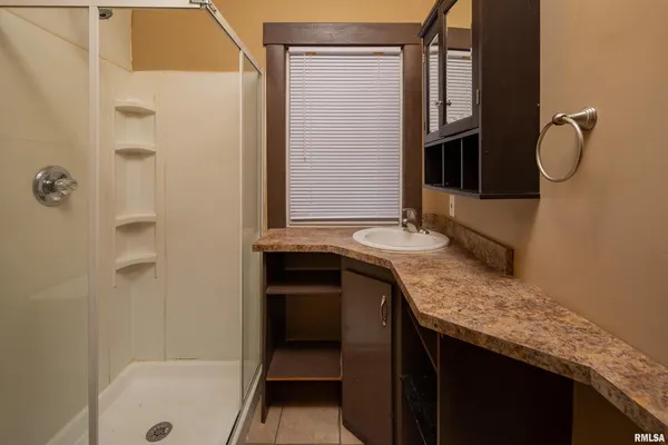 a bathroom with a granite countertop sink and a mirror