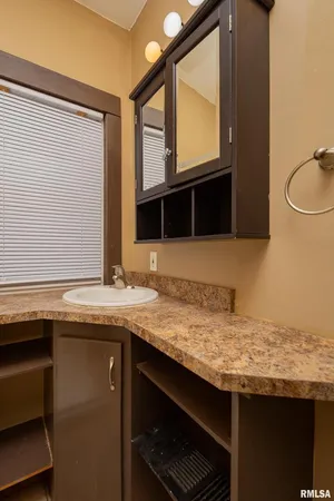 a bathroom with a granite countertop sink and a mirror
