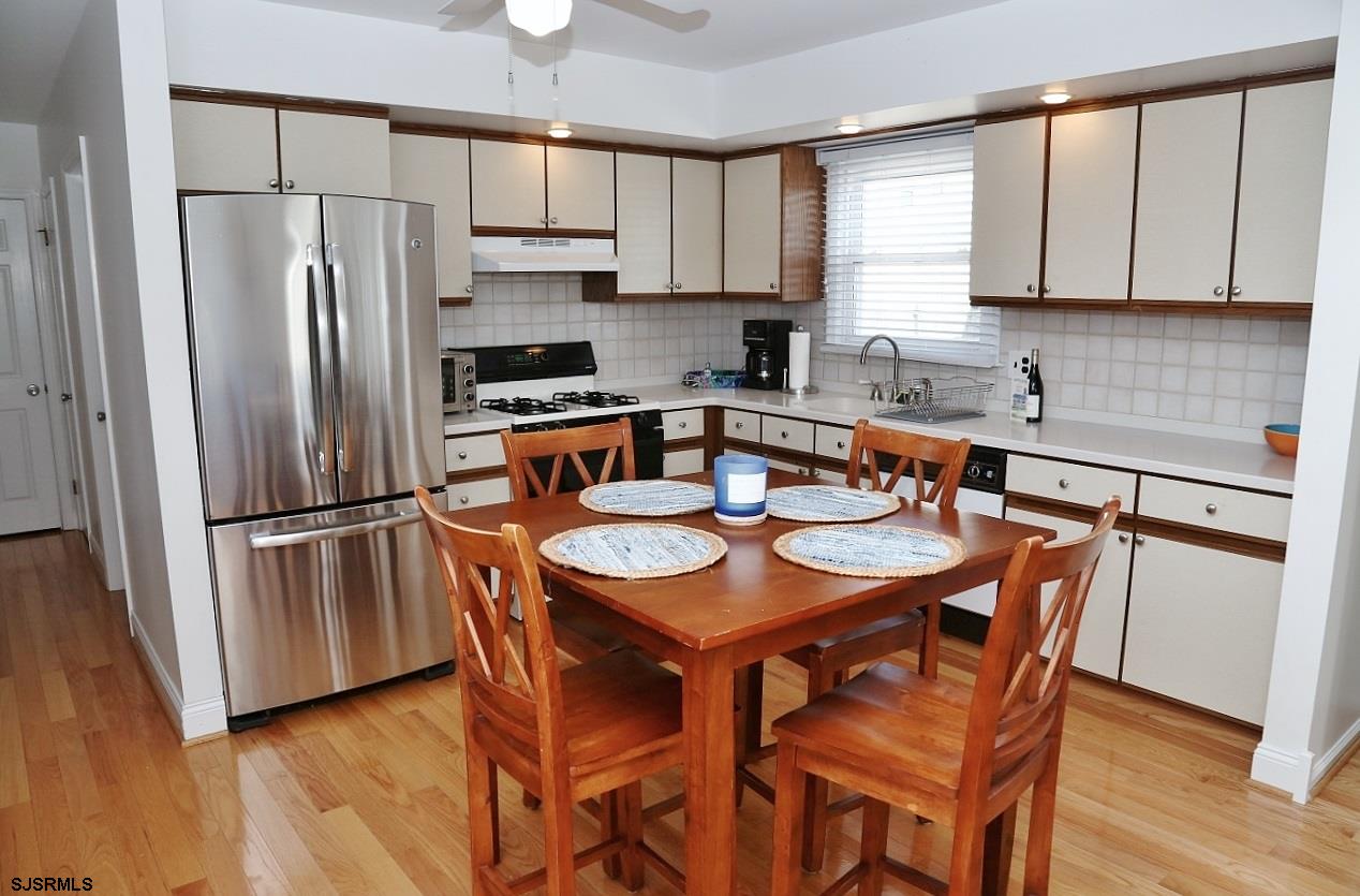 215 27th Street South Brigantine, NJ 08203 - Photo 11 of 23 a kitchen with stainless steel appliances granite countertop a refrigerator a sink a stove a dining table and chairs