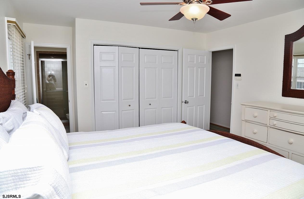 215 27th Street South Brigantine, NJ 08203 - Photo 17 of 23 a spacious bedroom with a bed and a chandelier