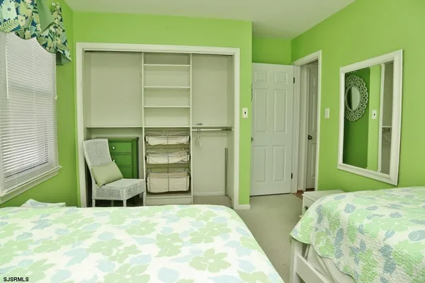 a bedroom with a bed chair and balcony