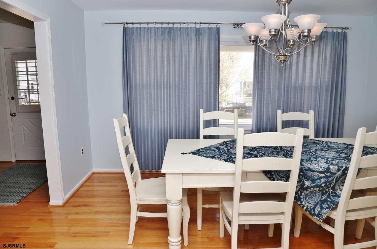215 27th Street South Brigantine, NJ 08203 - Photo 6 of 23 a dining room with furniture a chandelier and wooden floor