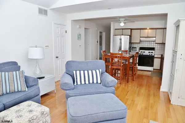 a living room with furniture and a wooden floor