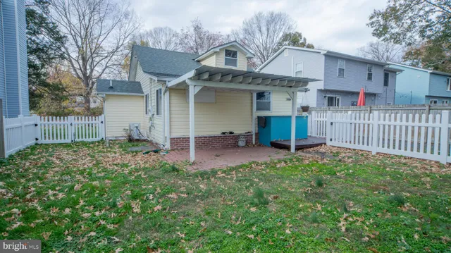 a view of a house with a small yard and wooden fence