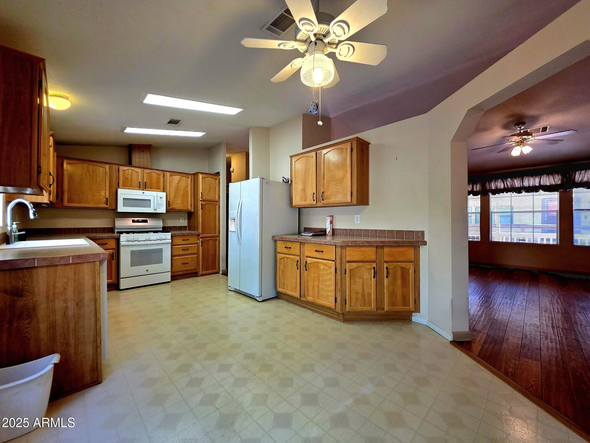 835 West Overland Road Payson, AZ 85541 - Photo 24 of 31 a view of a kitchen with kitchen island a sink wooden floor and stainless steel appliances
