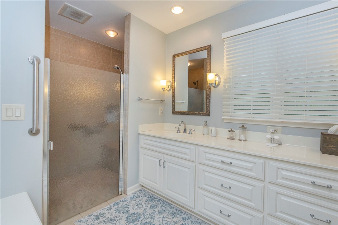 203 Oak Hollow Pendleton, SC 29670 - Photo 23 of 50 White cabinetry, solid surface counters, and a tiled shower create a functional bathroom space.