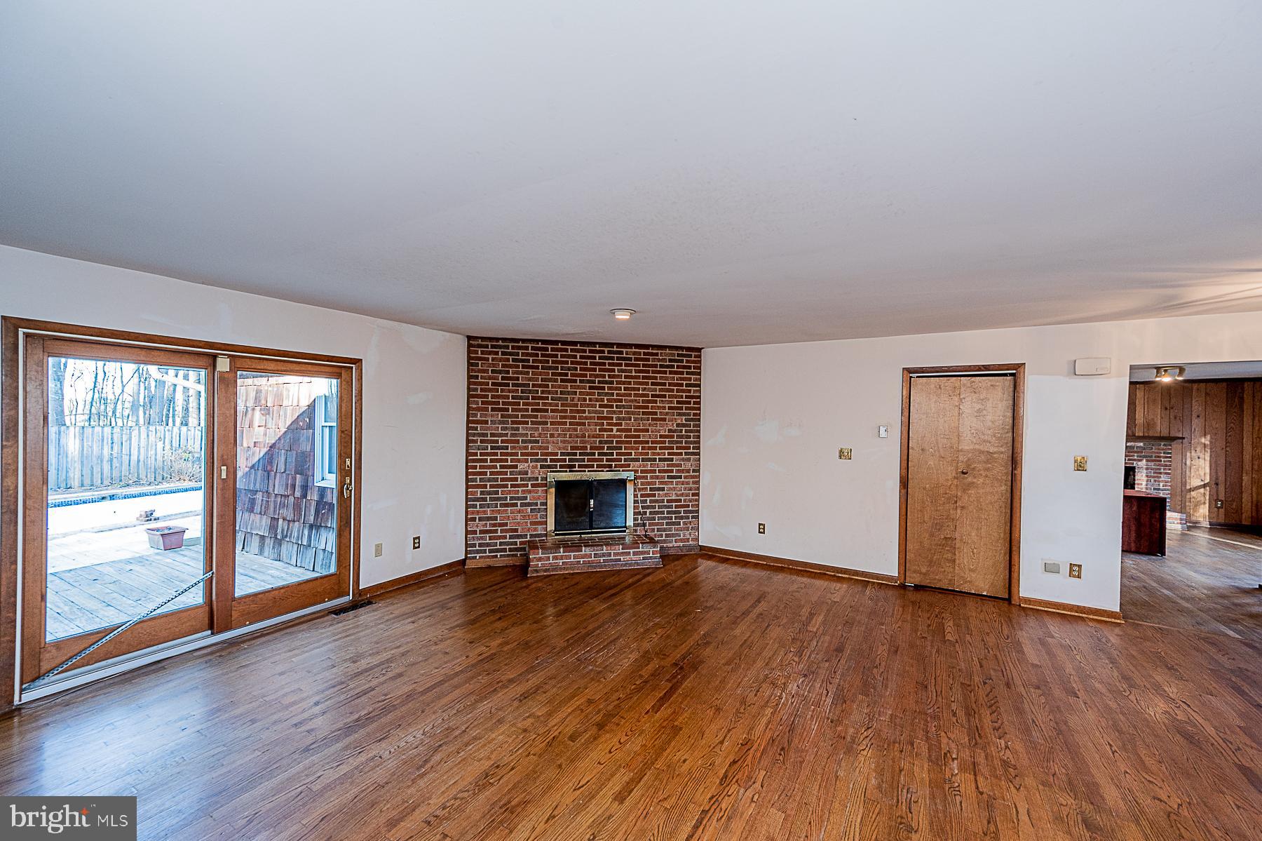 12008 Mettee Road Marriottsville, MD 21104 - Photo 11 of 36 wooden floor fireplace and windows in an empty room