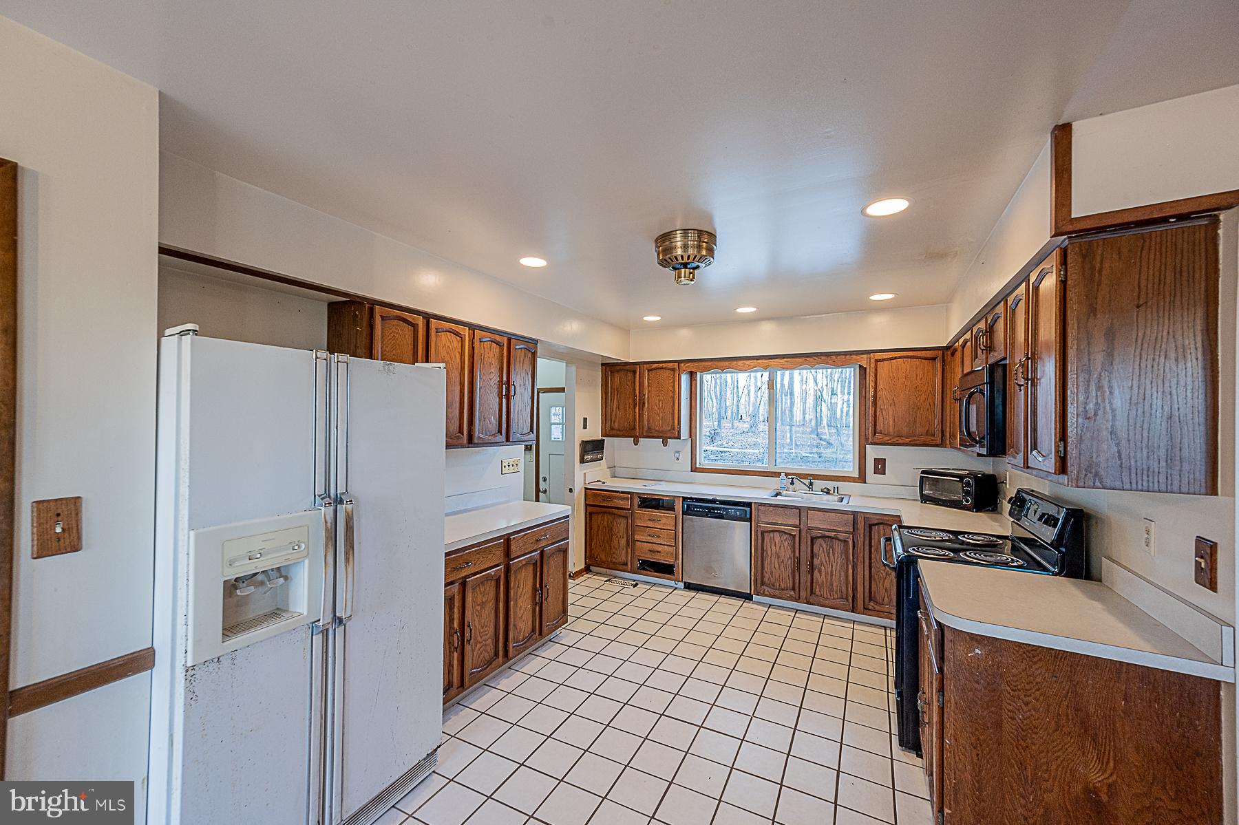 12008 Mettee Road Marriottsville, MD 21104 - Photo 12 of 36 a kitchen with stainless steel appliances granite countertop a refrigerator sink and cabinets
